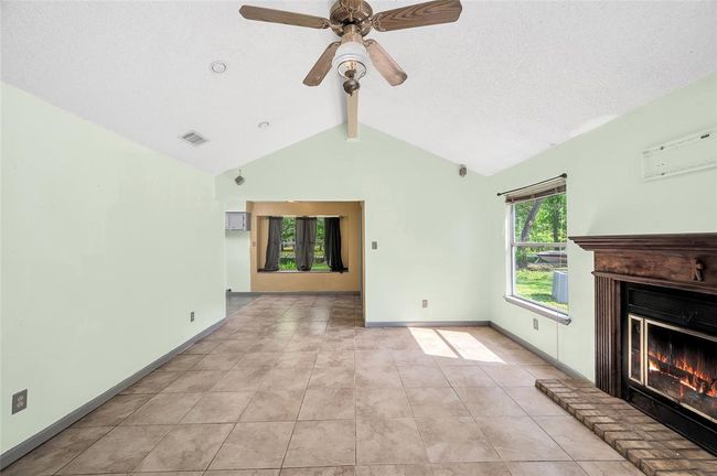Experience seamless living from the inviting entry to the spacious pantry. This open-concept space features elegant tile flooring, abundant natural light, and a cozy fireplace, perfect for comfortable living and entertaining. | Image 20