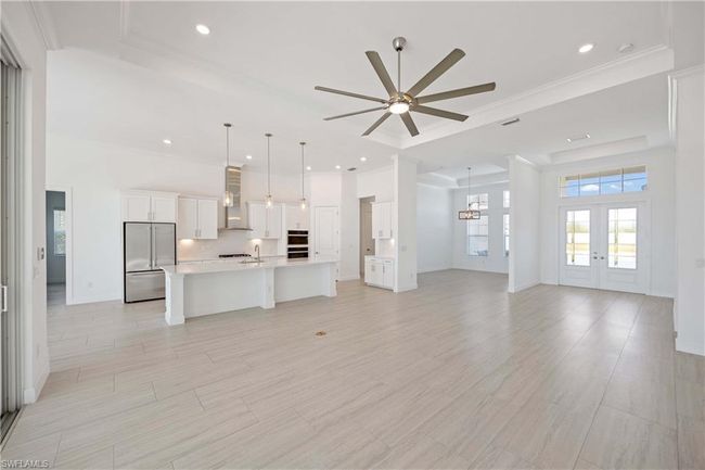 Unfurnished living room featuring french doors, ornamental molding, ceiling fan, and a sink | Image 6