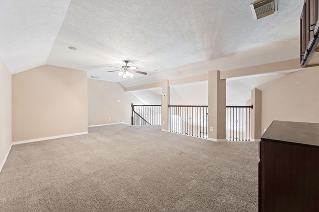 Bonus room upstairs with ceiling fan and built-in cabinets. Perfect for a play room, poker area, office space, and many other possibilities! | Image 37
