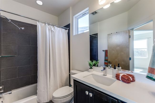 Bathroom with toilet, visible vents, shower / bath combination with curtain, and vanity | Image 25