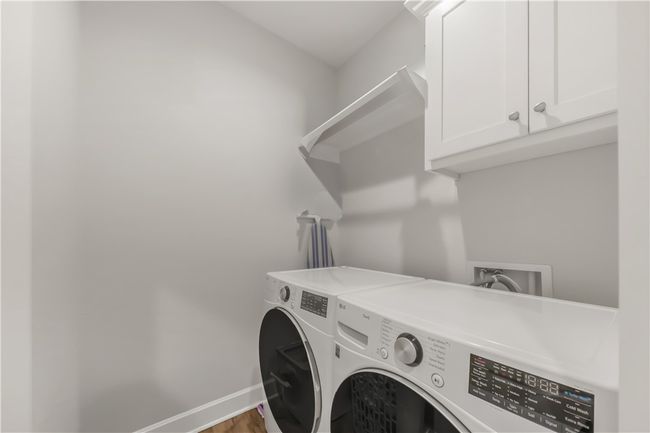 Laundry area with independent washer and dryer, cabinet space, and wood finished floors | Image 12