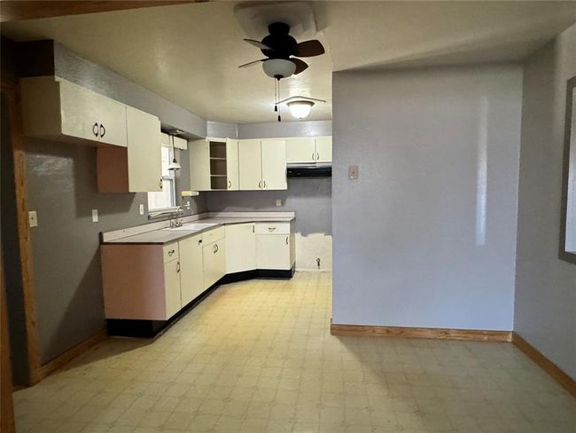 Kitchen featuring white cabinetry, sink, ceiling fan, and light tile floors | Image 22