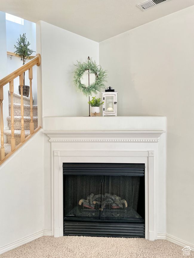 Detailed view of carpet flooring, a fireplace, and baseboards | Image 13