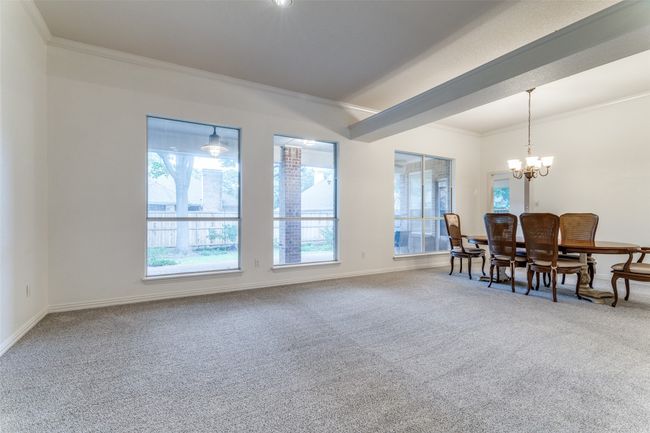 Carpeted dining room featuring a chandelier, baseboards, and ornamental molding | Image 7