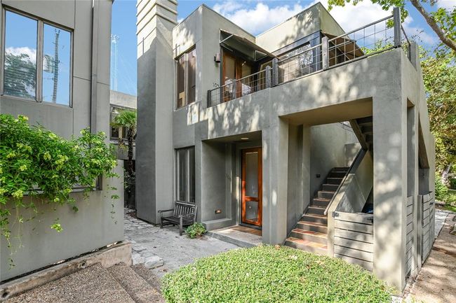 Property entrance with stucco siding and a balcony | Image 5