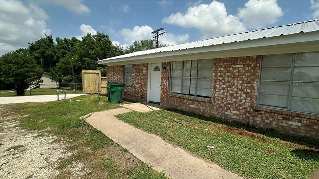 Doorway to property with brick siding and a yard | Image 7