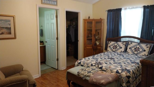 Bedroom featuring wood finished floors, a spacious closet, and ensuite bathroom | Image 7