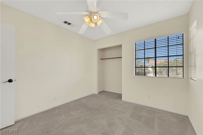 Unfurnished bedroom with a ceiling fan, light colored carpet, a closet, and visible vents | Image 31