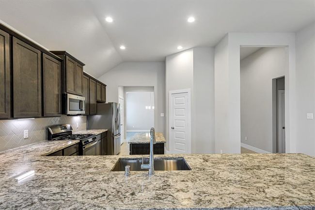 Kitchen with large bar for seating and prep space. | Image 11