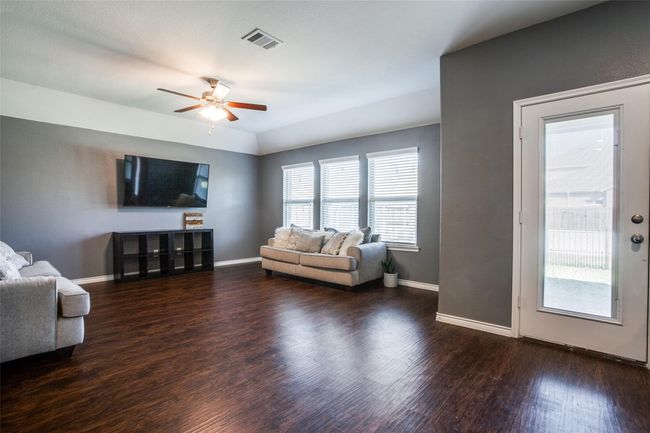 Living room featuring dark wood-type flooring and ceiling fan | Image 5