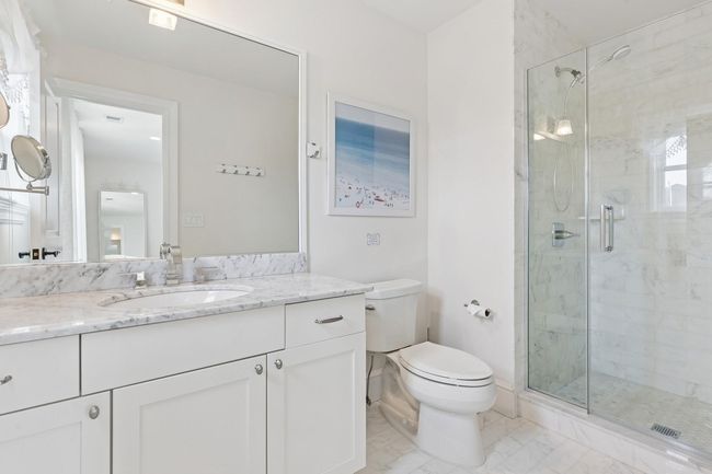 Bathroom with a stall shower, toilet, vanity, and marble look tiles | Image 21