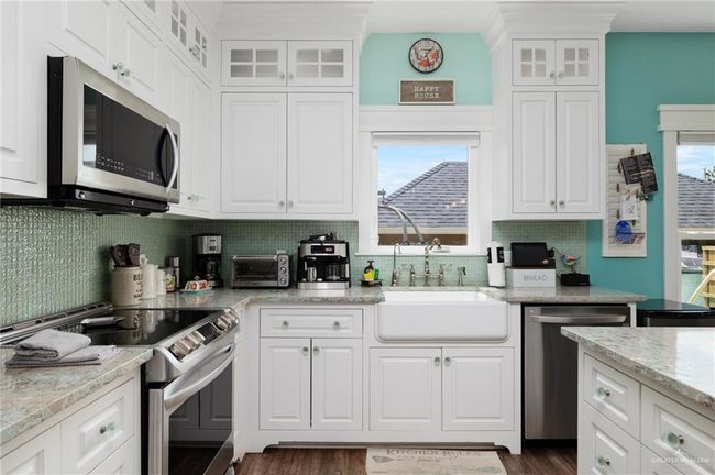 Kitchen featuring white cabinetry and appliances with stainless steel finishes | Image 4
