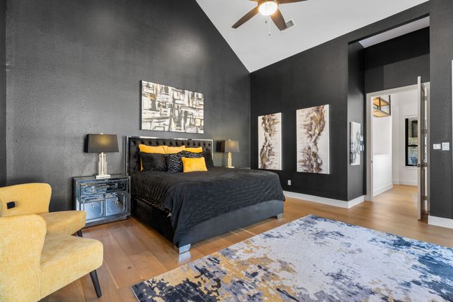 Bedroom featuring baseboards, high vaulted ceiling, wood finished floors, and a ceiling fan | Image 13