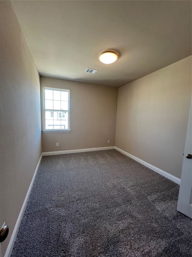 Spare room featuring visible vents, dark carpet, and baseboards | Image 12