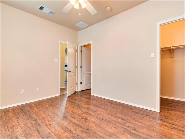 The main floor primary suite adds to the allure of this home, with its walk-in closet and private ensuite bath. | Image 14