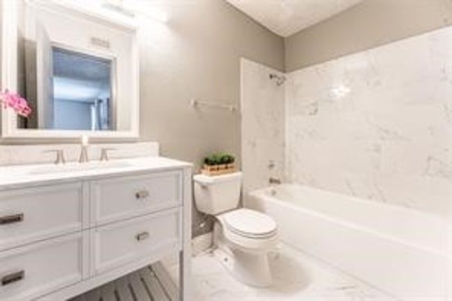 Bathroom with marble look tile flooring, vanity, and shower / bath combination | Image 21