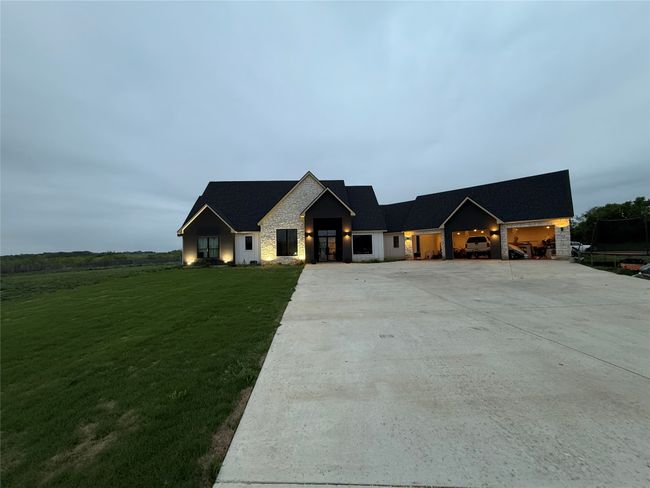 View of front of home with stone siding, a front lawn, and driveway | Image 35