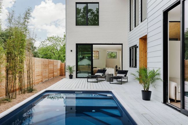 View of swimming pool featuring a deck, outdoor lounge area, and fence | Image 7