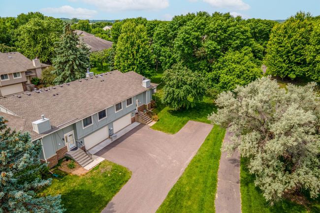 Nestled in a serene, tree-lined community, this home enjoys a peaceful location with abundant greenery and neighboring homes set at a comfortable distance. | Image 29