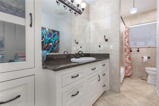 Bathroom featuring tile walls, tile patterned floors, vanity, and toilet | Image 23