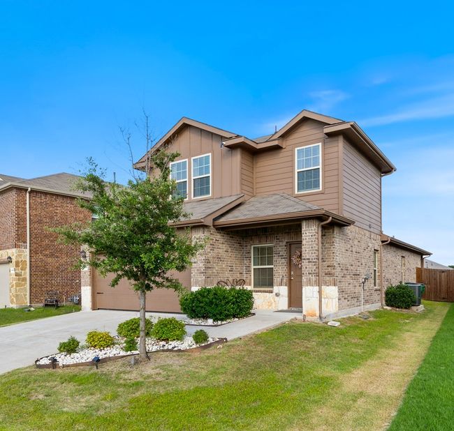 Traditional-style house featuring concrete driveway, brick siding, and an attached garage | Image 33