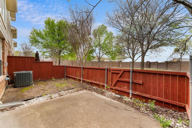 View of yard featuring a fenced backyard, a gate, central air condition unit, and a patio area | Image 25