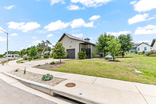 View of front of home with a garage, driveway, a front lawn, and a residential view | Image 15