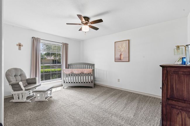Bedroom with carpet flooring, a nursery area, and ceiling fan | Image 23
