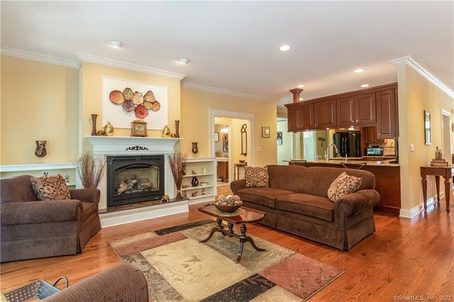 This beautiful living room features a gas fireplace with an air blower, granite hearthstone, and built-in bookcases. | Image 12
