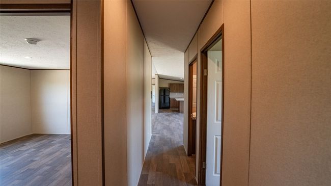 Corridor with dark wood finished floors and a textured ceiling | Image 15