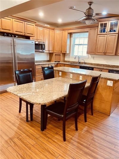 Kitchen with a kitchen island, stainless steel appliances, and light wood-type flooring | Image 3