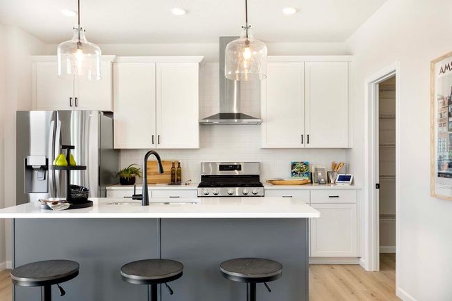 The kitchen island is complemented by designer pendant lighting, adding a touch of sophistication and style. Photos are from previously built home; options and features will vary. | Image 11