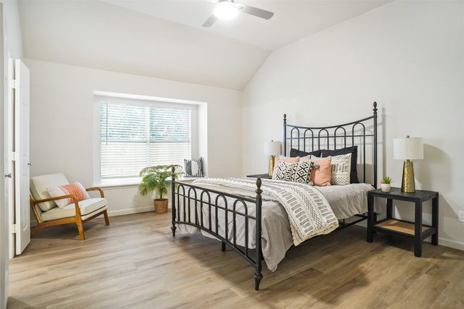 Bedroom with light wood-style flooring, vaulted ceiling, baseboards, and a ceiling fan | Image 13