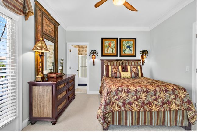 Bedroom with light colored carpet, ornamental molding, multiple windows, a ceiling fan, and ensuite bath | Image 32