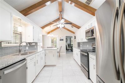 Kitchen with stainless steel appliances, white cabinetry, tasteful backsplash, and sink | Image 2