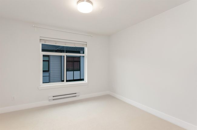 Spare room with a baseboard heating unit, carpet, and baseboards | Image 26