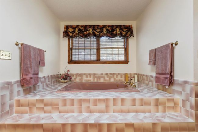 Bathroom featuring a textured ceiling and tiled tub | Image 27