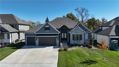 View of front facade with cooling unit, a garage, and a front lawn | Image 3