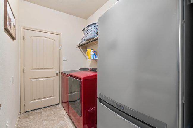Laundry room featuring light tile patterned floors, laundry area, and washer and clothes dryer | Image 23
