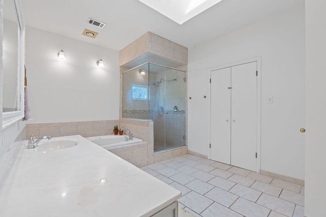 Bathroom featuring a garden tub, tile patterned floors, a stall shower, and a skylight | Image 24