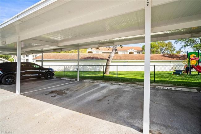 Covered parking lot featuring fence and playground community | Image 34