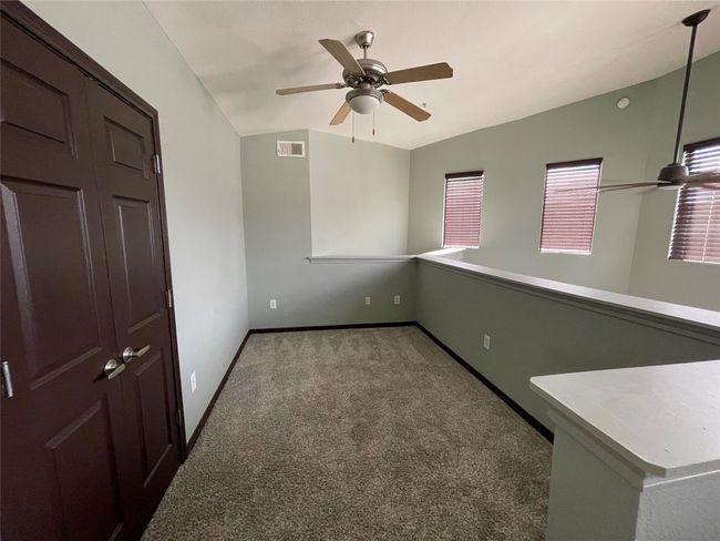 Unfurnished room featuring carpet flooring, a ceiling fan, baseboards, and lofted ceiling | Image 21