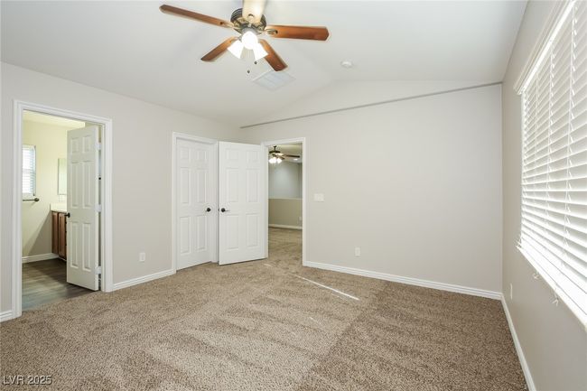 Unfurnished bedroom featuring carpet, a closet, vaulted ceiling, and baseboards | Image 9