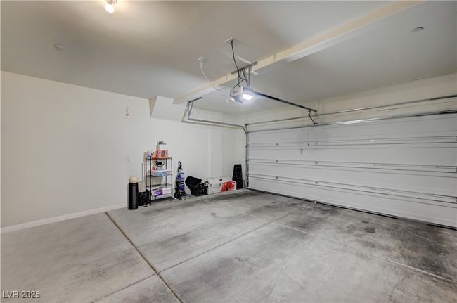 Garage featuring a garage door opener and baseboards | Image 26