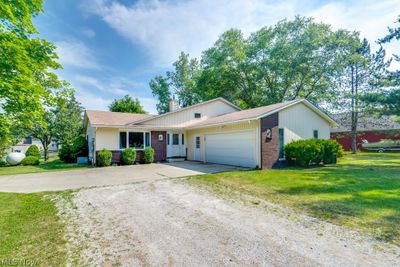 Single story home featuring a front yard and a garage | Image 1