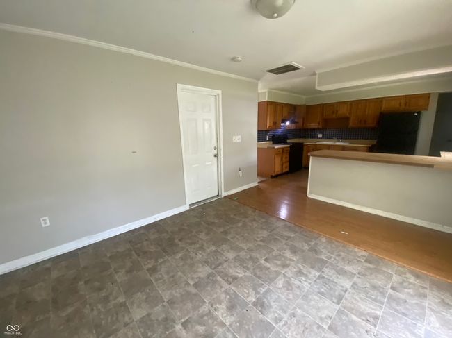 kitchen featuring tasteful backsplash, fridge, brown cabinets, and ornamental molding | Image 4
