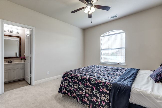 Bedroom with light colored carpet, ensuite bath, and a ceiling fan | Image 19