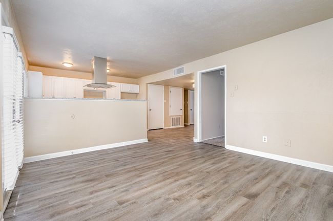 Unfurnished living room featuring light wood-type flooring and baseboards | Image 11