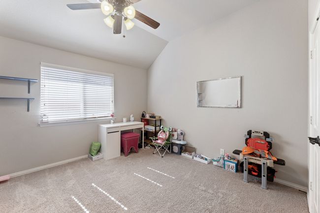Recreation room with lofted ceiling, visible vents, carpet, and a ceiling fan | Image 20