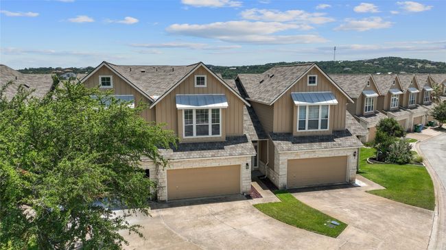 Multi unit property featuring stone siding, board and batten siding, a garage, and concrete driveway | Image 30
